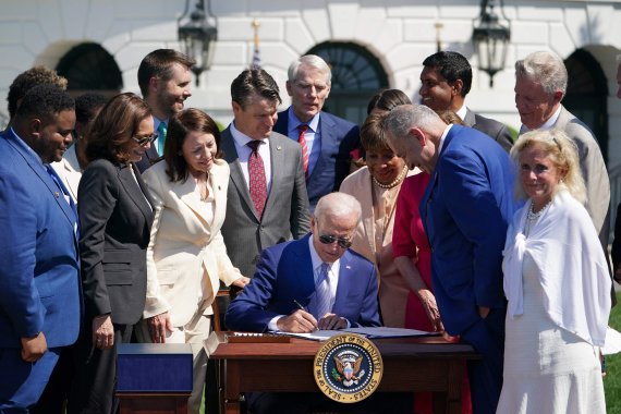 조 바이든(가운데) 미국 대통령이 9일(현지시간) 워싱턴 백악관 외곽의 사우스론에서 카멀라 해리스(왼쪽 2번째) 부통령 등이 지켜보는 가운데 &#39;2022 반도체와 과학법&#39;에 서명하고 있다. AFP연합