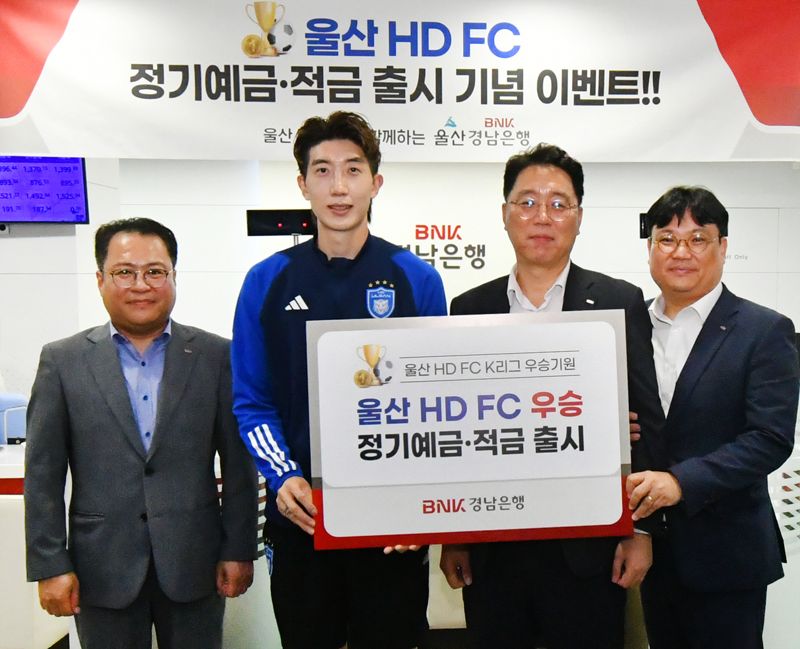 김형태 BNK경남은행 부장(왼쪽 세번째)과 울산 HD FC 조현우 선수(왼쪽 두번째) 등이 ‘울산 HD FC 우승 예적금 출시 증서&#39;를 들고 기념촬영을 하고 있다. 사진&#x3D;경남은행 제공