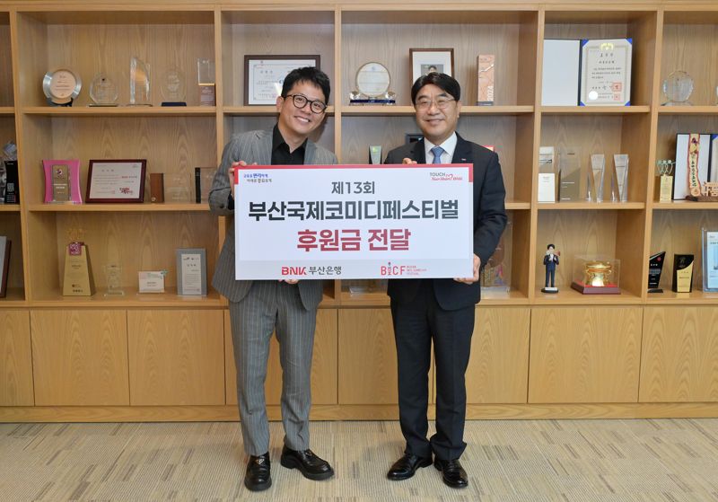BNK부산은행 방성빈 은행장(오른쪽)이 김준호 부산국제코미디페스티벌 집행위원장에게 후원금을 전달한 후 기념사진을 촬영하고 있다. 부산은행 제공 