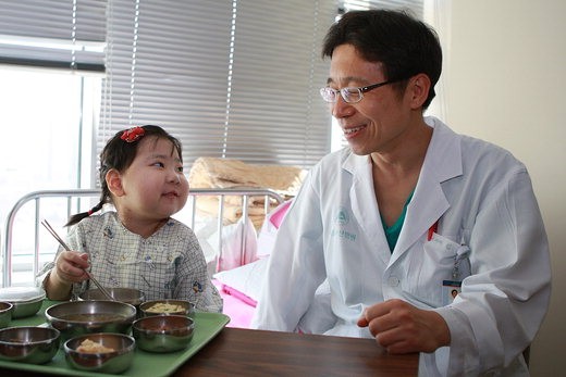 서울아산병원 소아외과 김대연 교수(오른쪽)가 조은서양이 밥 먹는 모습을 지켜보며 흐뭇해하고 있다.