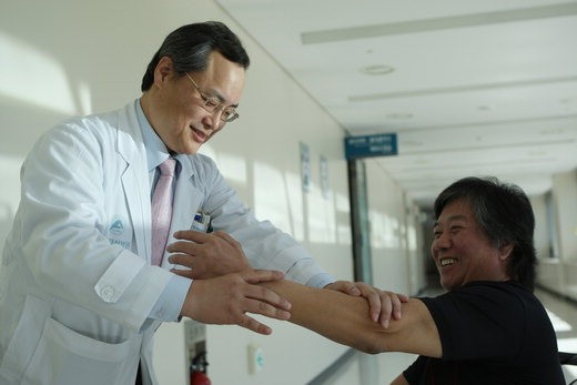 전상용 교수(왼쪽)가 줄기세포 치료에 성공한 박모씨의 팔 근력을 측정하고 있다.