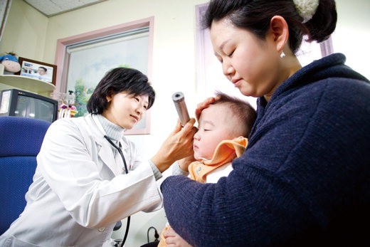 한림대 강남성심병원 소아청소년과 성태정 교수(왼쪽)가 중이염에 걸린 아이를 진료하고 있다.