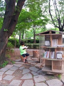 남산도서관 야외 책 보관함인 '다람쥐문고'에서 한 어린이가 책을 읽고 있다.