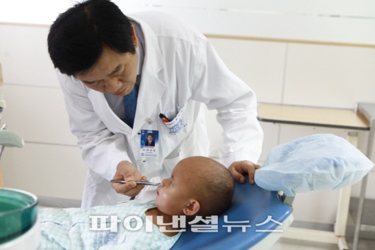 서울대학교치과병원 구강악안면외과 최진영 교수가 타마르의 수술부위를 살피고 있다.