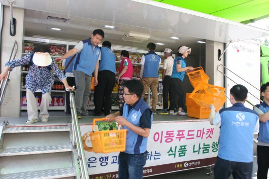 지난 14일 신한은행 자원봉사자들이 서울 영등포구청앞 광장에서 열린 저소득층 주민들을 위해 찾아가는 식품 나눔행사인 '이동 푸드마켓' 행사에서 자원봉사활동을 펼치고 있는 모습.