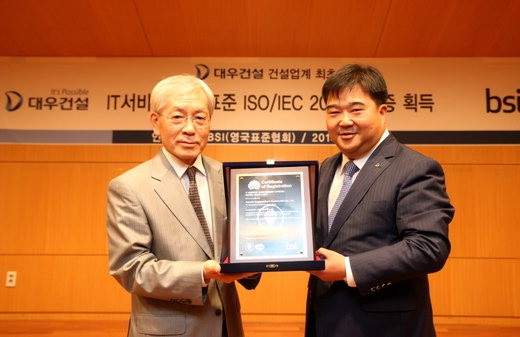 이훈복 대우건설 경영지원실장(오른쪽)과 천정기 BSI Korea 회장이 ISO/IEC 20000 인증패를 들고 기념촬영을 하고 있다.