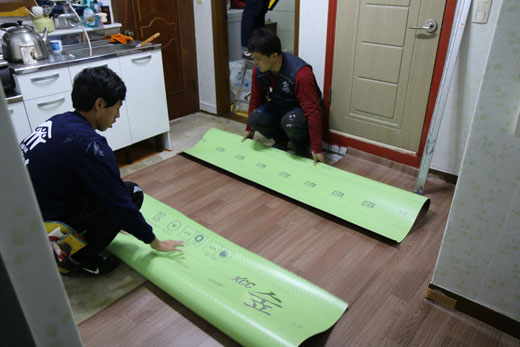 KCC가 한국 해비타트에 무상으로 제공한 친환경 바닥재 'KCC 숲 블루'를 지난 22일 한국 해비타트 자원봉사자들이 서울시 도봉구 한 가정에 시공하고 있다.