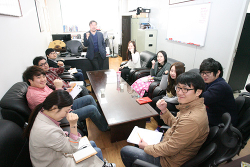 윤영중 대표(가운데)와 에바인 직원들이 회의 도중 함께 파이팅을 외치고 있다.