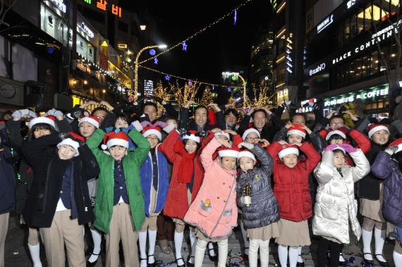 19일 저녁 열린 '2014 신촌 연세로 크리스마스 거리축제' 개막식에서 문석진 서대문구청장과 우상호 국회의원 등 내빈들이 이날 캐럴공연을 선사한 서대문구립소년소녀합창단 어린이들과 함께 손으로 하트 모양을 그려 보이고 있다