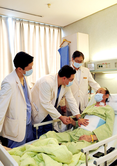 삼성서울병원 장기이식센터 김종만 교수(왼쪽 두번째)가 '바이오 인공 간' 시술을 받은 환자를 진찰하고 있다.