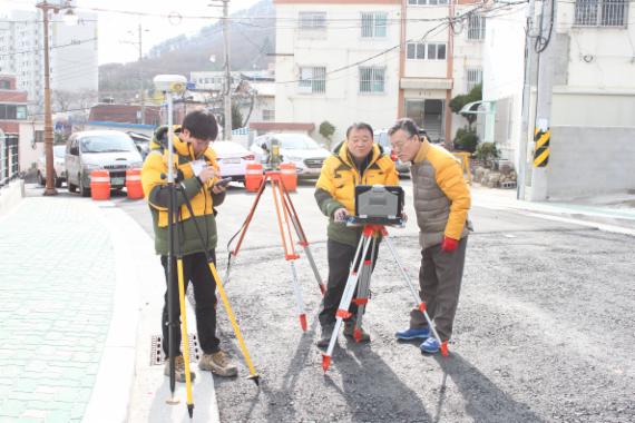 대한지적공사 부산·울산지역본부 소속 박흥식 팀장(가운데)과 민종대 담당관(오른쪽), 정성규 주임이 연산2지구 지적재조사 사업 현장에서 측량작업을 하고 있다.