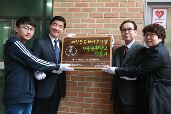 서울 강동구청과 동신중학교가 지난 3일 '폐식용유 자원 순환학교 만들기 협약식'을 가진 뒤 행사 참가자들이 현판을 붙이고 있다. 왼쪽부터 시계방향으로 동신중학교 학생대표, 이해식 강동구청장, 류인선 동신중학교 교장, 김희경 강동송파환경연합 사무국장.