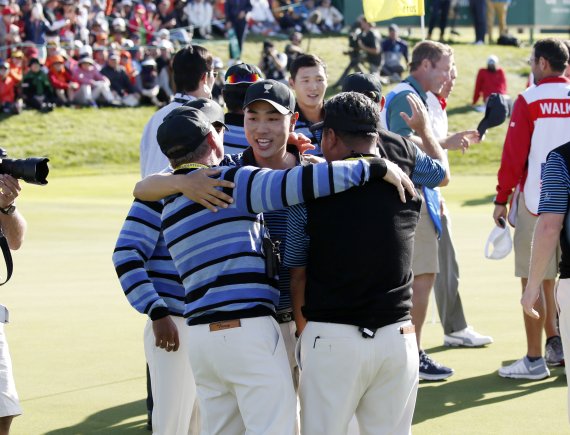 10일 인천 송도 잭 니클라우스GC서 열린 2015프레지던츠컵 사흘째 오후 포볼 경기서 승리한 배상문(가운데)이 인터내셔널팀 단장 닉 프라이스와 부단장 최경주(오른쪽)의 축하를 받고 있다.