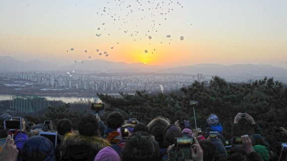 서울 광진구는 해마다 새해 1월1일 아차산에서 해맞이 축제를 연다고 21일 밝혔다. 사진은 지난해 시민들이 해맞이 축제에 참석해 떠오르는 해를 보며 풍선을 날린뒤 소원 등을 빌고 있는 모습.