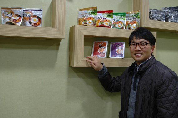 30일 김정훈 참미푸드 대표가 수출 제품과 함께 포즈를 취하고 있다.