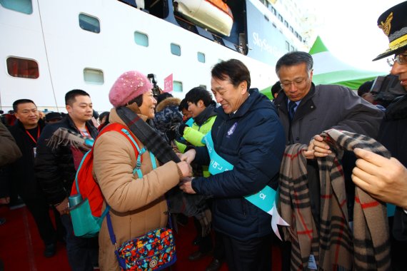 정창수 한국관광공사 사장(오른쪽 두번째)이 동해항 첫 크루즈 입항 환영 행사에서 중국인 관광객에게 기념품(목도리)을 전달하고 있다.