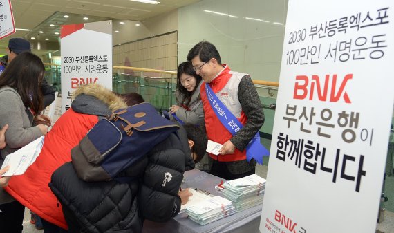 BNK금융그룹 부산은행 희망드림봉사단이 부산 대연동 경성대 지하철 역에서 '2030 부산등록엑스포 유치' 서명을 받고 있다.