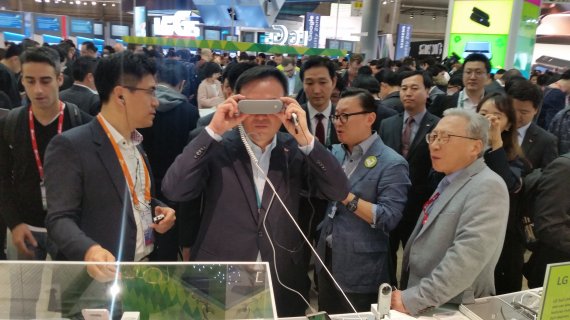 ▲장동현 SK텔레콤 사장(가운데)이 MWC 2016 현장에서 VR기기를 체험하고 있다.