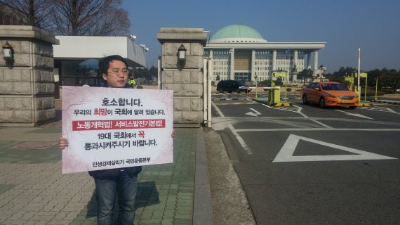 민생살리기 국민운동본부 관계자가 4일 서울 여의도 국회 정문 앞에서 경제활성화 관련 법안 처리를 촉구하는 1인 시위를 하고 있다.