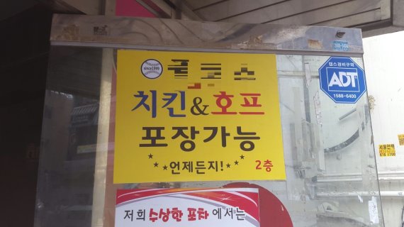 지난 22일 서울 고척동 고척스카이돔 주변 한 치킨 판매점 간판에 야구공이 그려져 있다. 고척돔 개장 이후 주변 상인들은 야구 관람객 증가로 매출 상승을 기대했지만 외부음식 반입 금지 정책이 논의되자 상권이 위축되지 않을까 우려하고 있다.