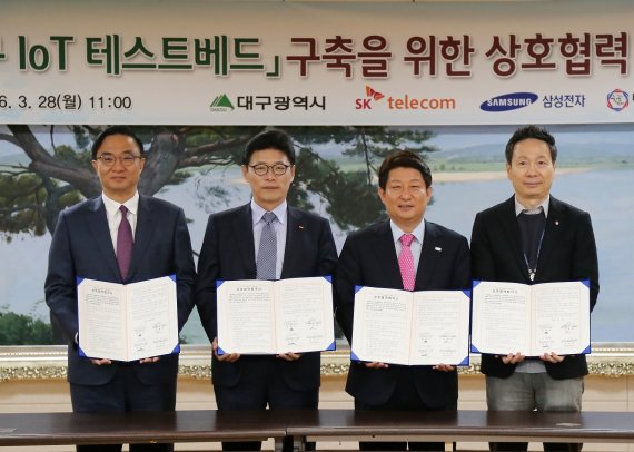 대구시와 SK텔레콤, 삼성전자가 28일 대구광역시 청사에서 '대구 IoT 테스트베드'를 구축하기로 협약을 맺었다. 김영기 삼성전자 사장, 이형희 SK텔레콤 사업총괄, 권영진 대구광역시장, 김선일 대구창조경제혁신센터장(왼쪽부터)이 기념촬영을 하고 있다.