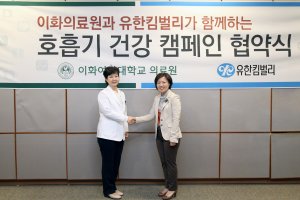 유경하 이대목동병원장(왼쪽)과 이호경 유한킴벌리 가정용품 사업부문장이 '호흡기 건강 캠페인'을 선포한 후 악수를 나누고 있다.