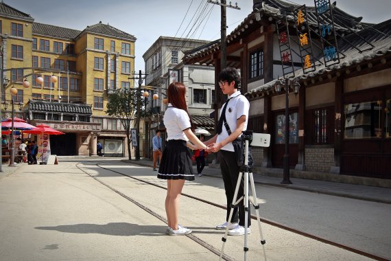 경남 합천영상테마파크에는 일제강점기 경성과 1970~80년대 서울 거리가 실감나게 재현돼 있어 추억여행지로 그만이다. 이곳을 찾은 여행객들이 교복을 입고 기념사진을 찍고 있다.