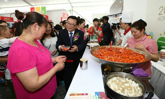 이동필 농림축산식품부 장관(왼쪽 두번째)이 4일 중국 시안에서 열린 '2016 K푸드 페어 시안'에서 방문객에게 한국음식을 소개했다. 이 장관은"건강기능성 식품인 삼계탕의 수출시장은 굉장히 커져 향후 중국이 최대 수출시장이 될 것"이라고 전망했다.