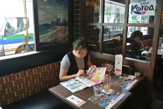 ▲한국관광홍보카페로 운영되고 있는 일본 트래블카페에서 일본인이 한국여행상품 리플렛을 보고 있다.