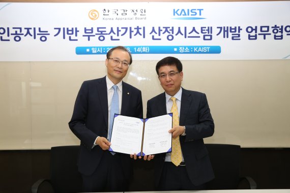 한국감정원 김양수 신사업본부장(왼쪽)과 카이스트 이문용 지식혁신연구센터장(오른쪽)이 14일 '인공지능 기반 부동산감정평가시스템 개발을 위한 업무협약' 체결 후 협약서를 들어 보이고 있다.