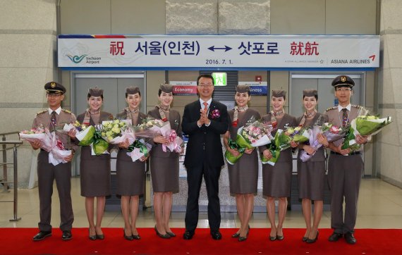 ▲1일 인천 운서동 인천국제공항 여객터미널 출국장에서 열린 아시아나항공 인천-삿포로 노선 신규 취항식에서 김수천 아시아나항공 사장(왼쪽 다섯번째)이 취항편 운항승무원 및 캐빈승무원들과 함께 기념촬영을 하고 있다.