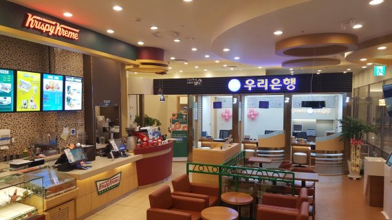 우리은행이 지난 6월 서울 잠실 롯데월드몰 지하 1층 '크리스피크림 도넛' 매장 안에 문을 연 컬래버레이션 2호점 '베이커리 인 브랜치'의 전경.