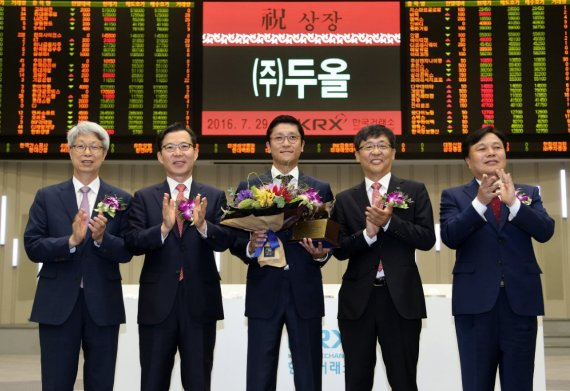 ▲한국거래소 코스닥시장본부는 29일 오전 서울 여의도 사옥 홍보관에서 자동차 시트원단 등 자동차 부품 제조업체인 두올의 유가증권시장 신규상장기념식을 개최했다. 이호철 한국IR협의회 회장, 조웅기 미래에셋증권 대표이사, 조인회 두올 대표이사, 이은태 한국거래소 유가증권시장본부장, 김진규 상장회사협의회 부회장(왼쪽부터)이 상장기념패 전달식 이후 기념촬영을 하고 있다.