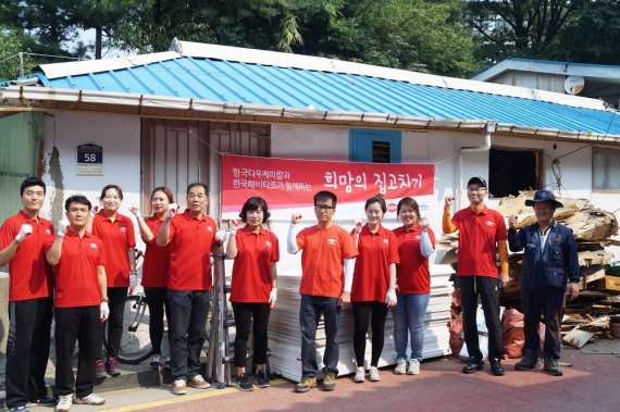 한국다우케미칼 임직원들과 헤비타트 관계자들이 지난 6월 수원지역 집고치기 활동을 마친후 기념촬영하고 있다.