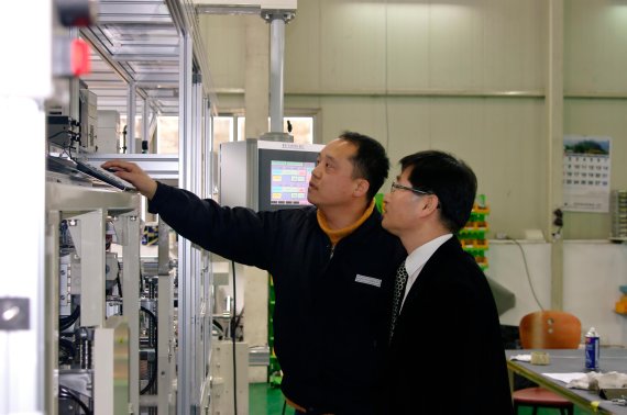 김수하 씨아이에스㈜ 대표(오른쪽)와 현장 실무자가 코팅된 전극의 시작과 끝에 테이프를 붙이는 테이프 라미네이터(Tape Laminator) 설비 운영에 대해 의견을 나누고 있다.