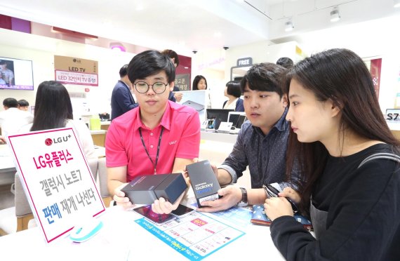 LG유플러스 대리점에서 직원이 고객들에게 갤럭시노트7 판매재개 소식을 알리고 있다.