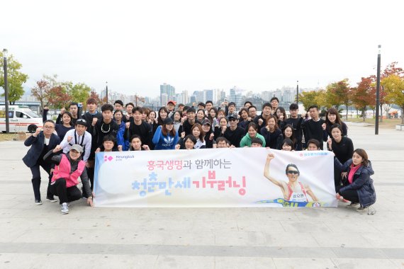 흥국생명이 개최한 '청춘만세 기부러닝' 마라톤 행사에서 참여한 사람들이 지난 29일 서울 여의도 한강공원에서 기념촬영을 하고 있다.