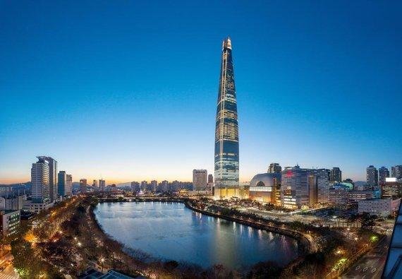 서울 잠실 롯데월드타워 42~71층에 들어서는 주거시설 '시그니엘 레지던스'의 분양 일정이 연기되면서 초고가 레지던스의 미분양 부담이 작용한 게 아니냐는 분석이 나오고 있다. 오는 2017년 초 전체 사용승인이 날 것으로 예상되는 롯데월드타워 야경.