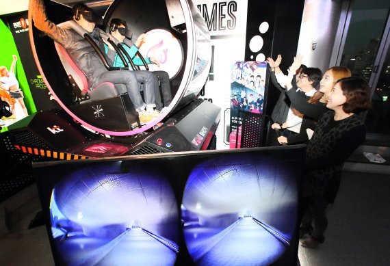 지난 13일 서울 동대문 K-라이브(live)에 구축된 '기가 VR 체험존'에서 관람객이 트와이스의 음악에 맞춰 서울, 평창 등의 관광명소를 둘러보는 원형 어트랙션을 체험하고 있다.
