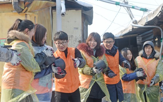 한화투자증권과 한화손해보험 신입사원 26명은 지난 20일 서울 개포동 구룡마을에서 연탄 1500장(총 기부는 5000장)을 도움이 필요한 이웃에게 전달하는 봉사활동을 펼쳤다.<div id='ad_body2' class='ad_center'></div> 신입사원들이 일렬로 서서 연탄을 나르고 있다. 사진=김범석 기자