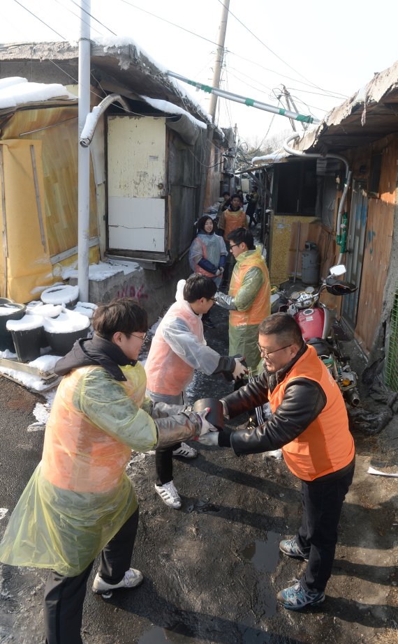 본지 윤경현 기자(맨 앞줄 오른쪽)가 한화투자증권, 한화손해보험 신입사원들과 연탄을 나르고 있다. 사진=김범석 기자