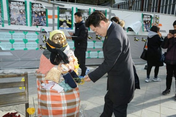 이재명 성남시장이 28일 서울 종로구 주한일본대사관 앞 소녀상을 찾아 시민들이 놓고 간 꽃을 살펴보고 있다.