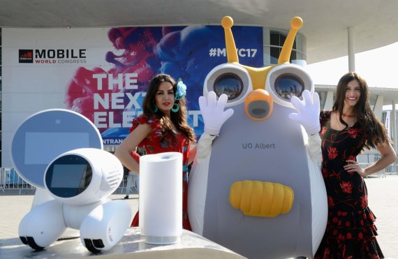 25일(현지시간) 오전 MWC 2017이 열리는 '피라 그란 비아(Fira Gran Via)' 전시장 앞에서 현지모델들과 SK텔레콤의 스마트 로봇 '알버트'가 차세대 AI 로봇 등을 올려 두고 포즈를 취하고 있다.