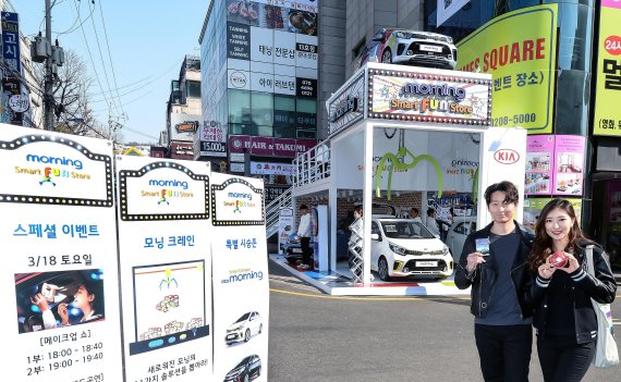 기아차가 서울 마포구 홍대 어울마당로 일대에 설치한 '모닝 스마트 펀 스토어'에서 모델들이 포즈를 취하고 있다.