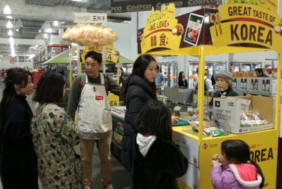 CJ제일제당이 일본 관서지역 코스트코 아마가사키점에서 진행한 '비비고 왕교자' 로드쇼에서 소비자들이 직원의 안내를 받으며 시식하고 있다.