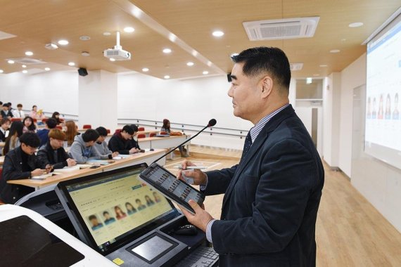중앙대 이명천 광고홍보학과 교수가 전자교탁 위에 설치된 전자출결시스템 단말기에서 출석현황을 확인하고 있다.
