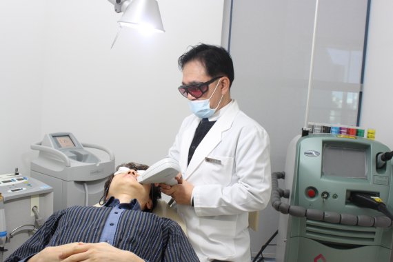 고우석 제이엠오피부과 원장이 남성 환자의 수염 부위에 레이저 제모시술을 하고 있다.