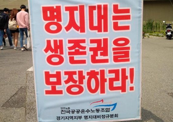 명지대 청소근로자들이 용역업체와 학교측의 근무시간 단축 꼼수로 피해를 본다며 점심시간에 맞춰 자연캠퍼스에서 피켓 시위를 벌이고 있다.