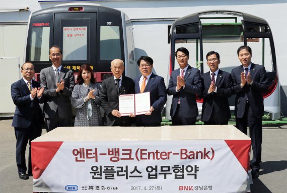 BNK경남은행은 27일 ㈜한국화이바, 에프유㈜와 각각 '엔터뱅크(Enter-Bank) 원플러스 업무협약'을 체결했다. 이번 협약에 따라 경남은행은 한국화이바, 에프유는 물론 임직원에게도 금융 지원이 원활하게 이뤄질 수 있도록 적극 협력키로 했다. 엔터뱅크 원플러스 업무협약은 기업(엔터프라이즈, Enterprise)과 은행(뱅크, Bank)이 하나로 뭉쳐 시너지효과를 내기 위한 상생제도다. 손교덕 경남은행장(왼쪽 다섯번째)이 조용준 한국화이바 회장(왼쪽 네번째)과 업무협약 체결 후 기념촬영하고 있다