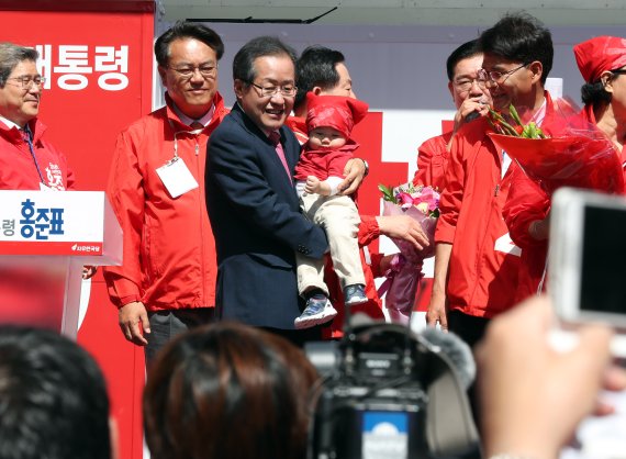 홍준표 자유한국당 대선후보가 4월 27일 충남 천안터미널 앞 광장에서 한 아이를 안고 인사하고 있다. 연합뉴스